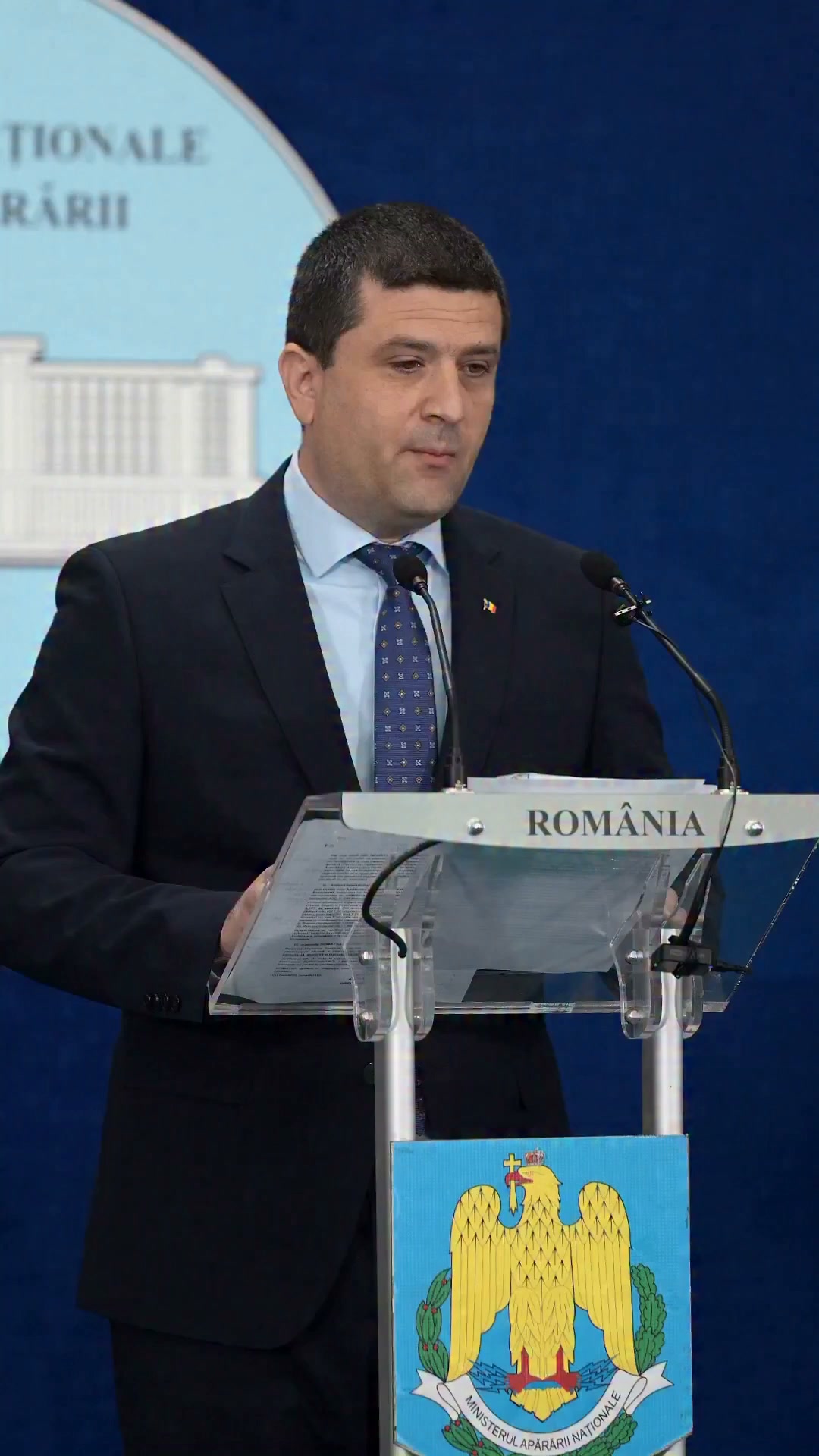 Radu Miruță, vice-premier ministre et ministre de la Défense nationale, s'exprimant à un pupitre portant l'emblème du ministère de la Défense nationale